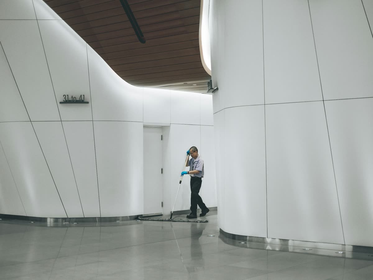A cleaning cart waiting in a quiet office corridor before dawn